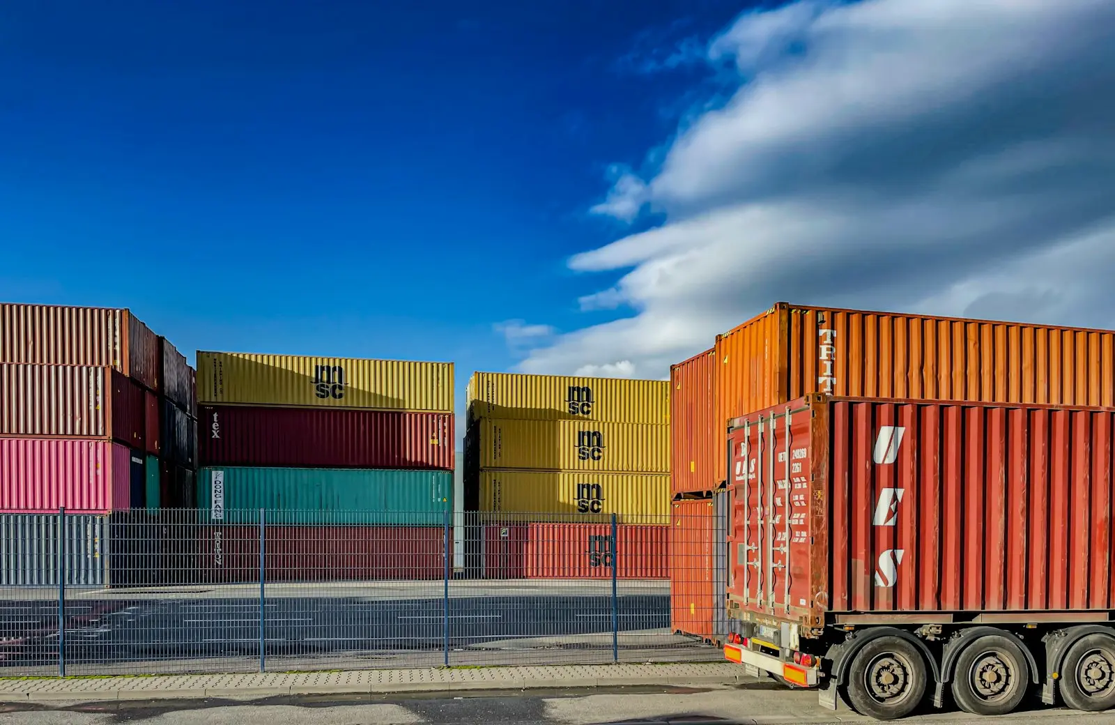 Prime mover hauling an orange shipping container