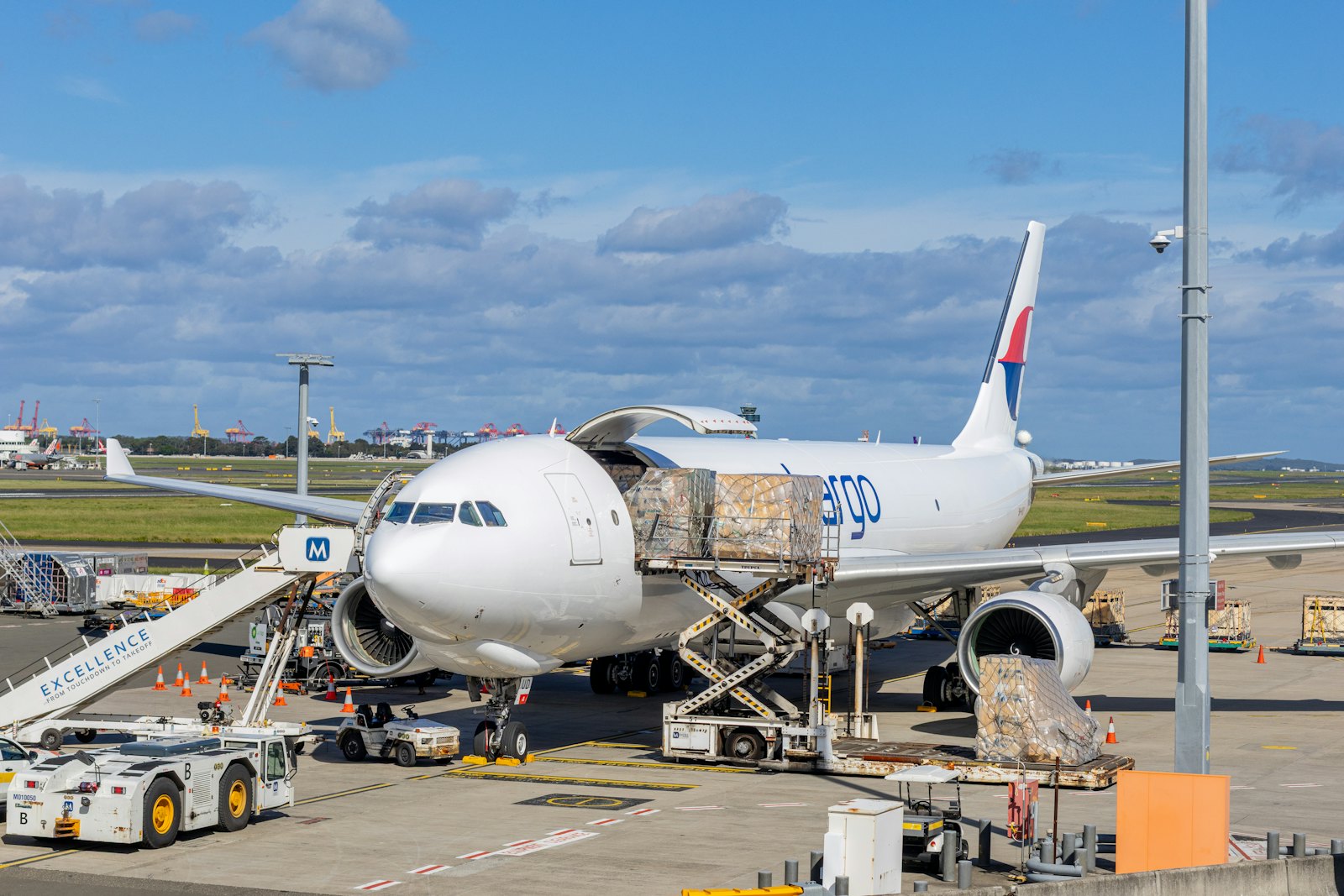 Freighter aircraft being loaded with cargo pallets on the apron