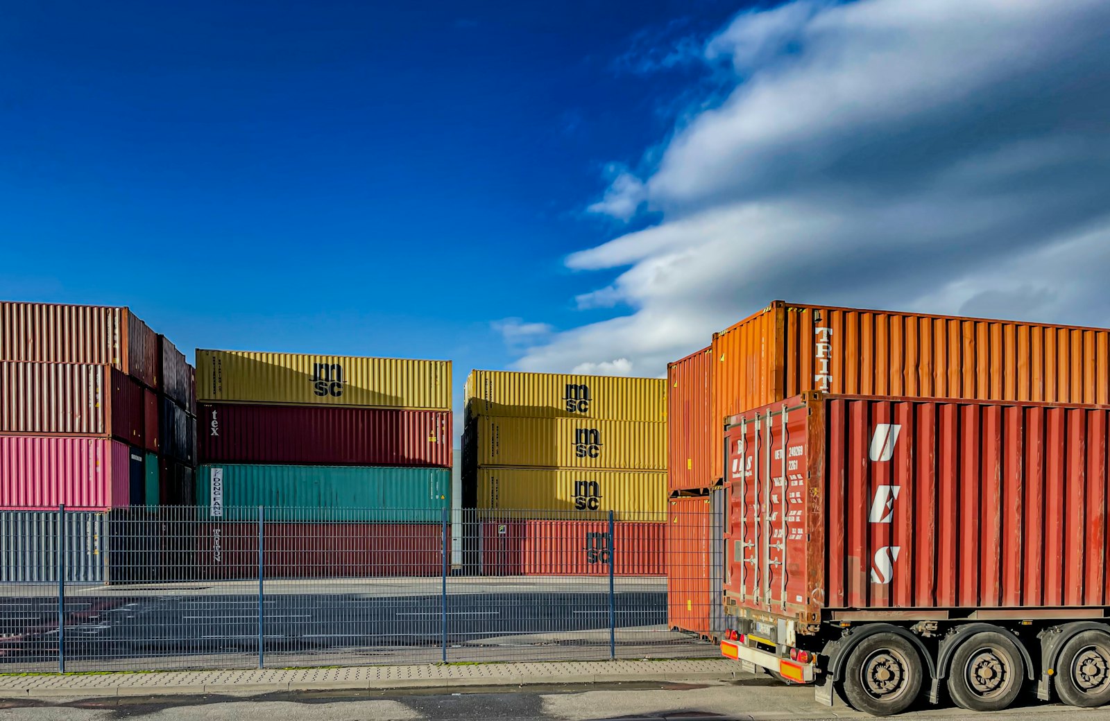 Prime mover hauling an orange shipping container